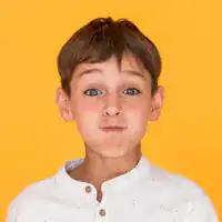 Child with funny face expression on yellow background.
