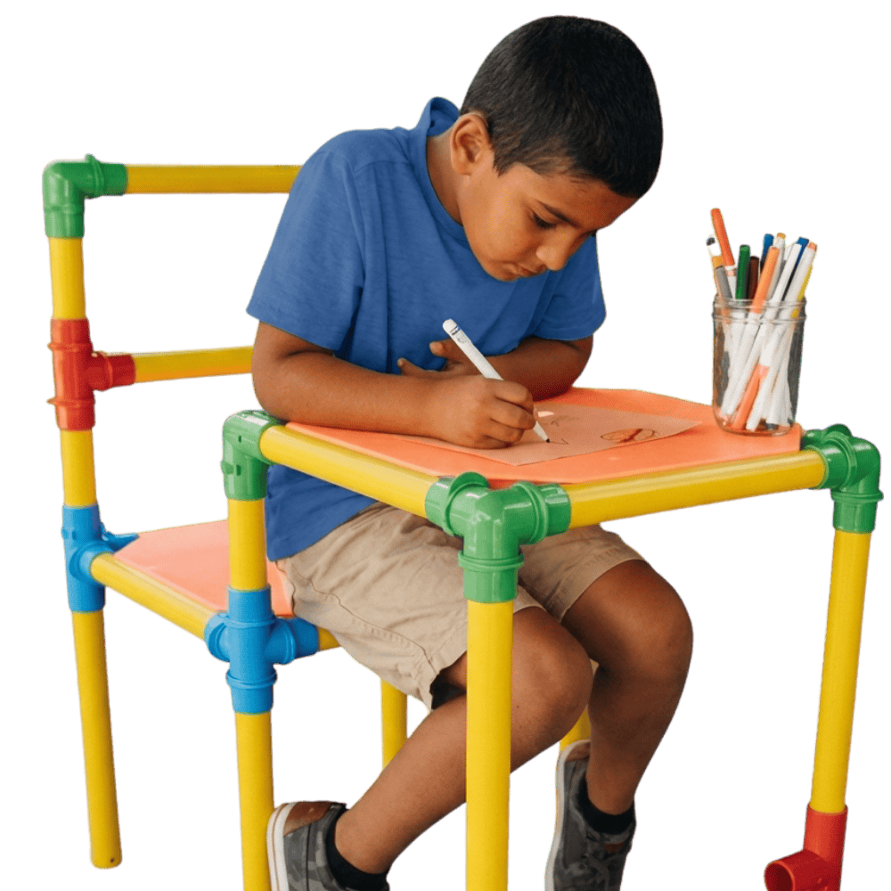 Child drawing at colorful kids' art table with markers and paper.