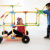 Kids building a colorful structure with Petra Play Ultimate Builder Set, 220 pieces.